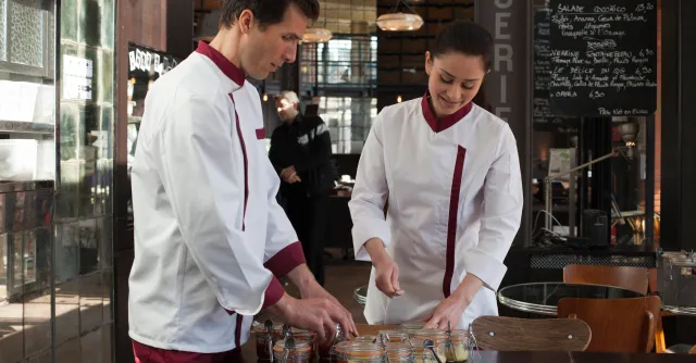 photo de deux personne qui preparent des conserves