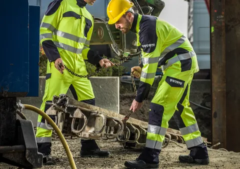 Deux personnes avec des vêtements de travail haute-visibilité de couleur jaune fluo / marine