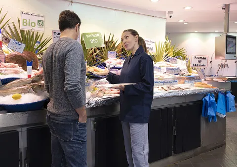 Un client parlant à la personne en charge du rayon poisson