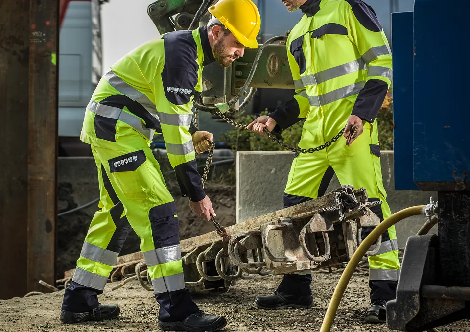 Deux personnes travaillant sur un chantier, en tenu jaune
