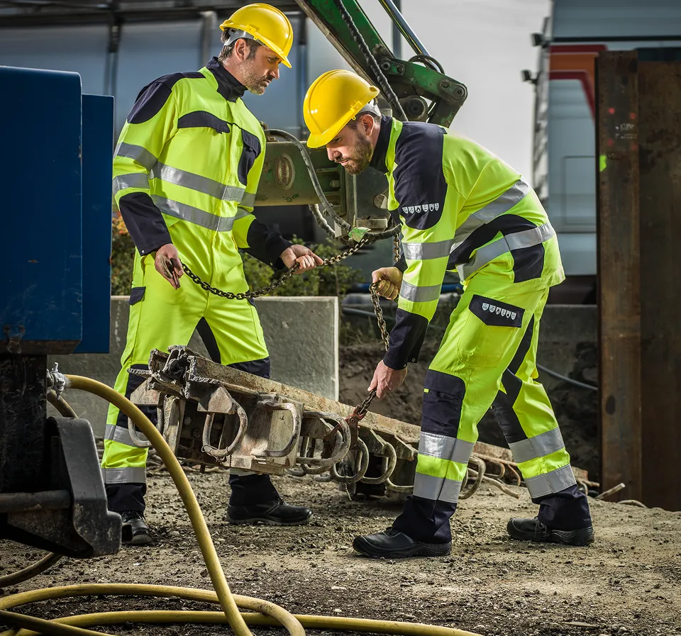 Deux personnes avec des vêtements de travail haute-visibilité de couleur jaune fluo / marine