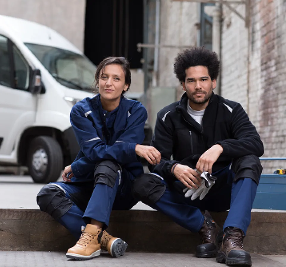 Deux personnes assisent portant des EPI de la collection streetwear